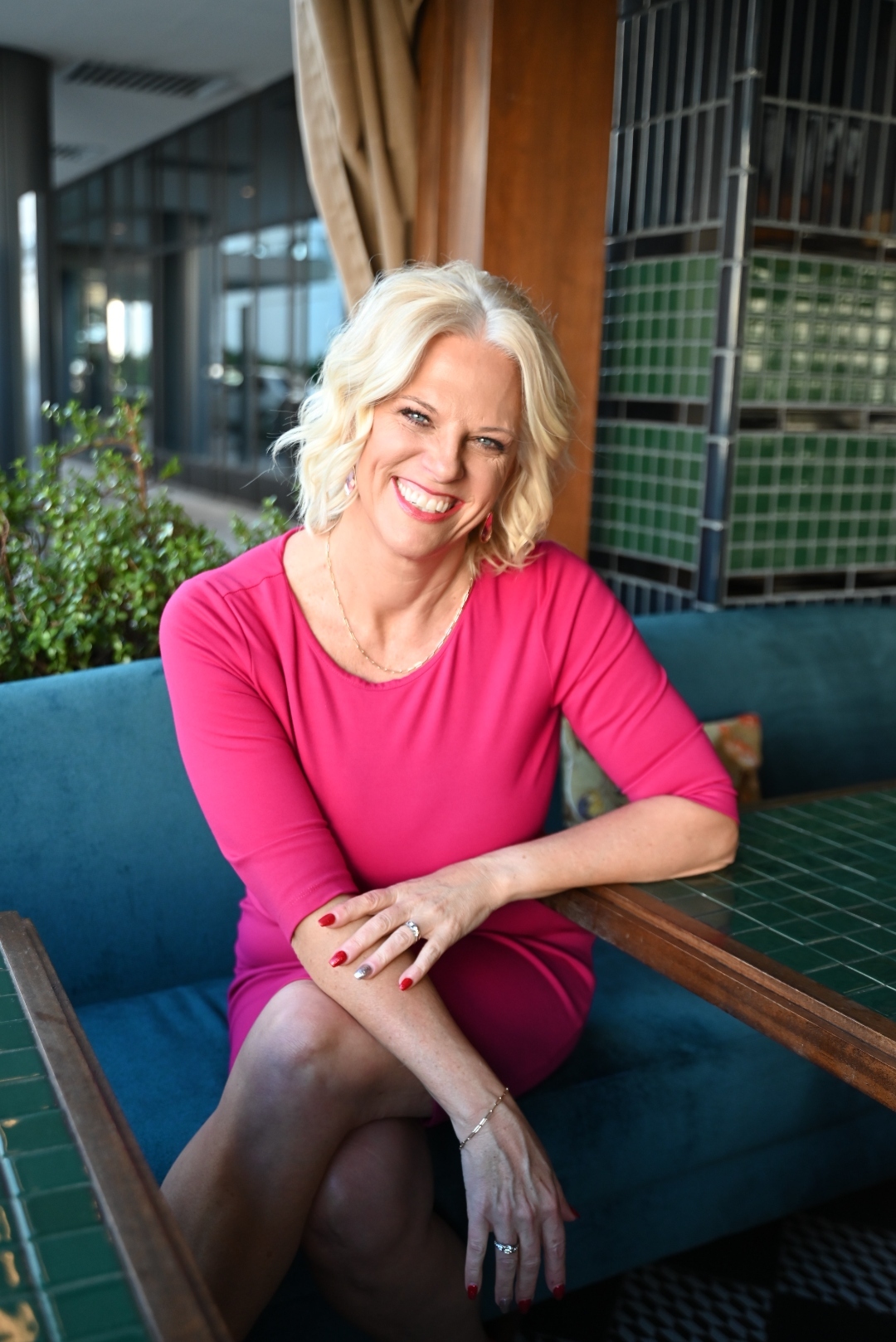 Jessica in a pink dress, seated and smiling