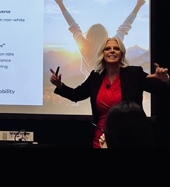 Jessica speaking on stage with presentation